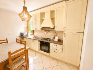 a kitchen with white cabinets and a table and a dining room at Casa Campomonte in Poppi