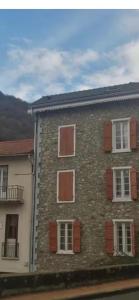 a brick building with white and red windows at Studio Cosy Ax-les-Thermes Centre in Ax-les-Thermes