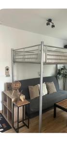 a bedroom with a bunk bed with a couch and a table at Studio Cosy Ax-les-Thermes Centre in Ax-les-Thermes