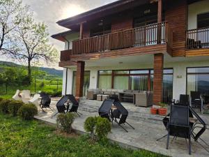 a patio with a bunch of chairs in front of a house at Къща за гости Торлашка среща in Vŭrbovo +4 photos