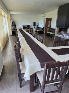 a long row of tables and chairs in a room at Къща за гости Торлашка среща in Vŭrbovo