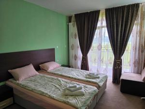 a bedroom with a bed and a large window at Къща за гости Торлашка среща in Vŭrbovo