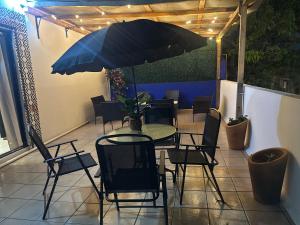 a table and chairs with an umbrella on a patio at Suites Xico Oaxaca in Oaxaca City