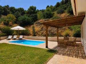 a backyard with a swimming pool and an umbrella at Wellness Farm Villa - Monte Valeo in Coín +28 photos