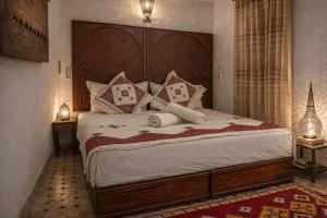 a bedroom with a large bed with a wooden headboard at Hotel Larayhana in Fez +24 photos