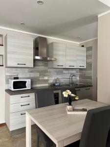 a kitchen with a table with chairs and a microwave at La Tavernetta in Casto