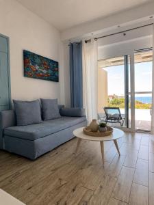 a living room with a blue couch and a table at Galinio Boutique Apartments in Skafidia
