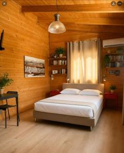 a bedroom with a bed in a room with wooden walls at Olive Grove in Anavyssos