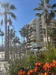 a view of a beach with palm trees and flowers at French Riviera Chic Cocoon - pool, beach, parking in Antibes