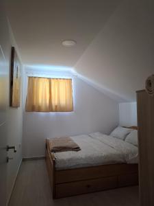 a bedroom with a bed and a window at Vikendica Garaski kutak sprat in Arandelovac