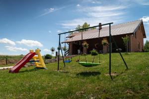 a yard with swings and a house at Vikendica Garaski kutak sprat in Arandelovac