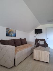 a living room with a couch and a chair at Vikendica Garaski kutak sprat in Arandelovac