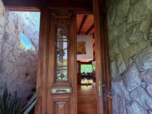a wooden door to a house with a stone wall at Un Espacio de Buscadores in Ingeniero Maschwitz