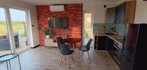 a kitchen with a table and chairs and a brick wall at Perła prosto z Borów in Cekcyn