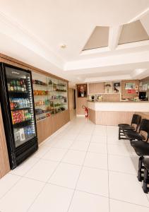 a room with a refrigerator and a counter with chairs at Hotel Nacional Arapiraca in Arapiraca