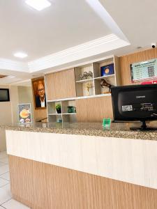 aacistacist standing at a counter in a dental office at Hotel Nacional Arapiraca in Arapiraca