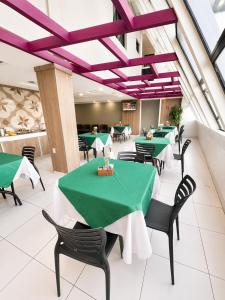 a dining room with green tables and black chairs at Hotel Nacional Arapiraca in Arapiraca +5 photos