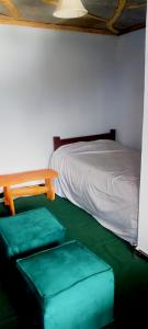 a room with a bed and a table and green seats at MATENI's B&B in Naivasha