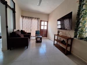 a living room with a couch and a tv at Departamento Arena- Oasis del Mar in Progreso