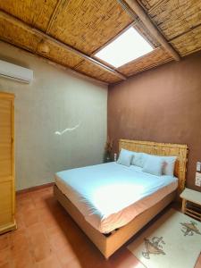 a bedroom with a large bed with a skylight at Darna in Marrakesh +16 photos
