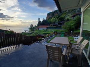a table and chairs on a porch with a view of the ocean at Apartman Riste in Trpejca