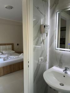 a white bathroom with a sink and a bed at Lukova Center Sunset Apartments in Lukovë