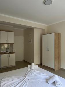 a bedroom with a large white bed and a kitchen at Lukova Center Sunset Apartments in Lukovë