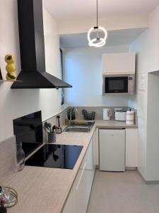 a kitchen with a sink and a microwave at Le Jaurès in Brie-Comte-Robert