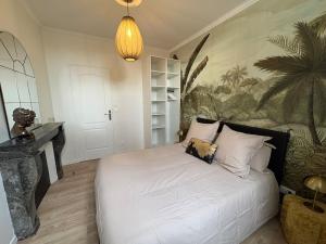 a bedroom with a bed with a painting on the wall at Le Jaurès in Brie-Comte-Robert