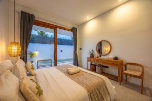 a bedroom with a large bed and a mirror at Anatha Villa Uluwatu in Badung +13 photos