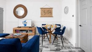 a living room with a table and blue chairs at Melbourne Place Apartment in Port Bannatyne