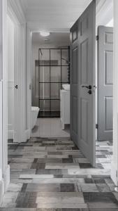 a white bathroom with a tub and a door at Melbourne Place Apartment in Port Bannatyne +4 photos