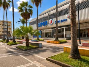 a shopping center with palm trees in front of it at Le Palm Loft in Pointe-à-Pitre
