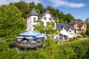 a large white building with blue umbrellas in front of it at Studios & Spa Suites Rigiblick in Zurich