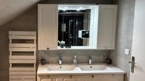 a bathroom with two sinks and a mirror at Maison charmante en bordure de la Creuse in Glénic +15 photos