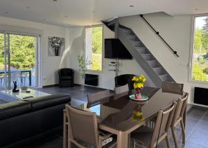 a living room with a table and a staircase at Maison charmante en bordure de la Creuse in Glénic