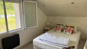 a small bedroom with a bed and a window at Maison charmante en bordure de la Creuse in Glénic