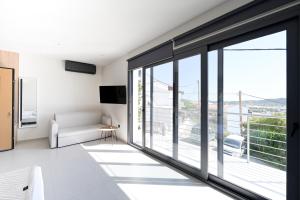 a living room with large windows and a couch at kallos of Skiathos in Skiathos