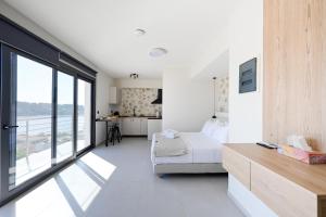 a bedroom with a bed and a large window at kallos of Skiathos in Skiathos