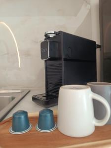 a coffee maker on a counter with cups and a coffee mug at Eden's Garden luxury Studio in Kalamitsi