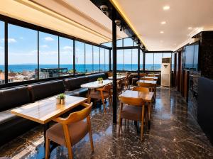 a restaurant with tables and chairs and large windows at G-25219Kaya Royal Hotel By Wsd Hotels Group in Istanbul
