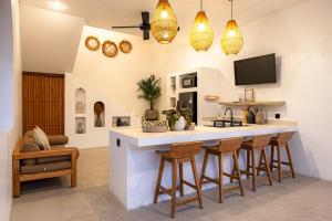 a kitchen with a bar with stools and a tv at Anatha Villa Uluwatu in Badung