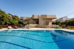 a swimming pool in front of a house at Villa Katrin in Ialysos