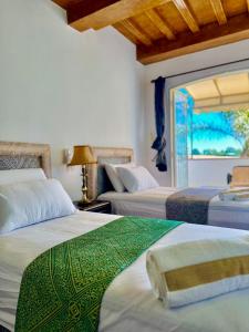 a bedroom with two beds and a window at Ferme Oasis de Fes in Fez +87 photos