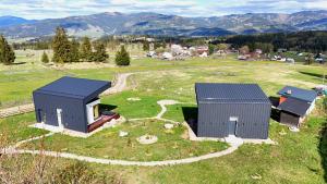 two buildings on a field with mountains in the background at La Cuiburi in Sărişor +14 photos