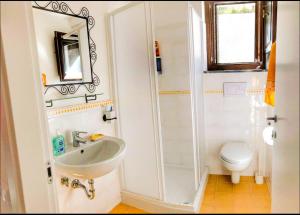 a bathroom with a sink and a toilet and a mirror at Casa Santicelli Maratea ' I CARPINI ' in Maratea +9 photos