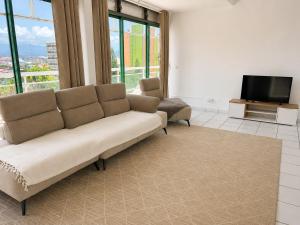 a living room with a couch and a tv at Le Palm Loft in Pointe-à-Pitre
