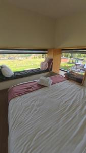a bed in a room with a large window at La Cuiburi in Sărişor