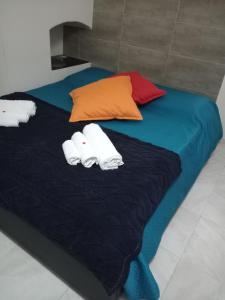 a bed with two pillows and towels on it at La Pergoletta in Molfetta