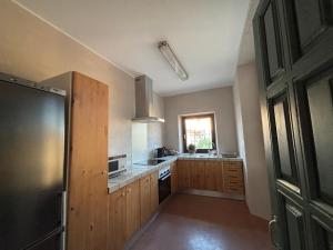 a kitchen with wooden cabinets and a sink and a refrigerator at Ca La Botera in Verges